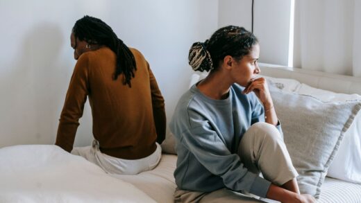Woman and man sitting on bed